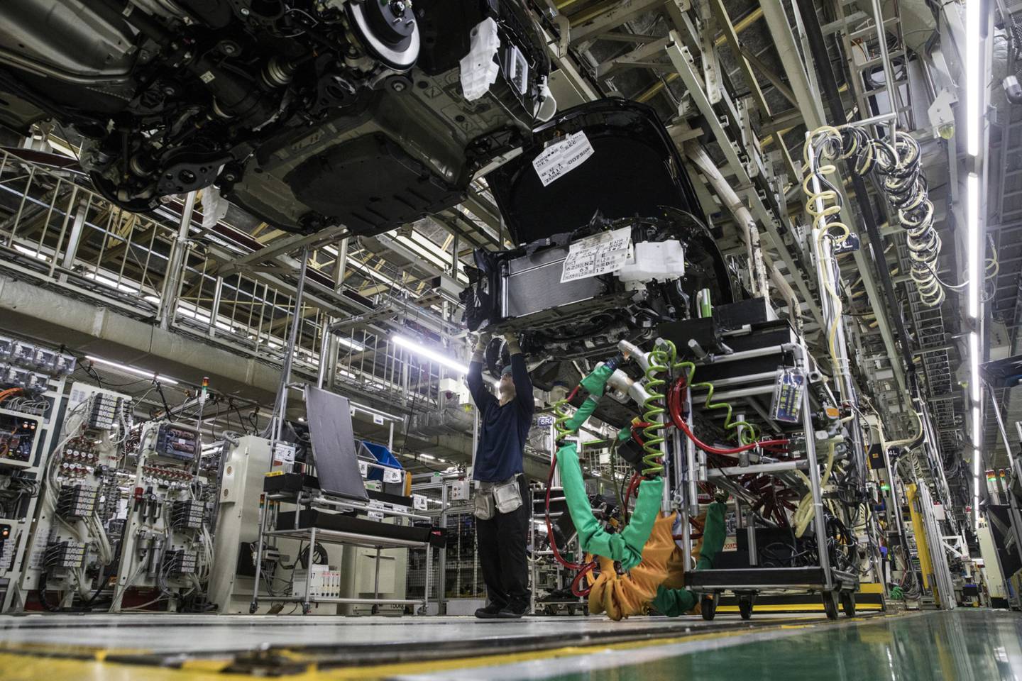 Un empleado de Toyota Motor Corp. instala un motor en un vehículo Crown en la línea de producción en la planta de Motomachi de la compañía en Japón, el jueves 26 de julio de 2018.