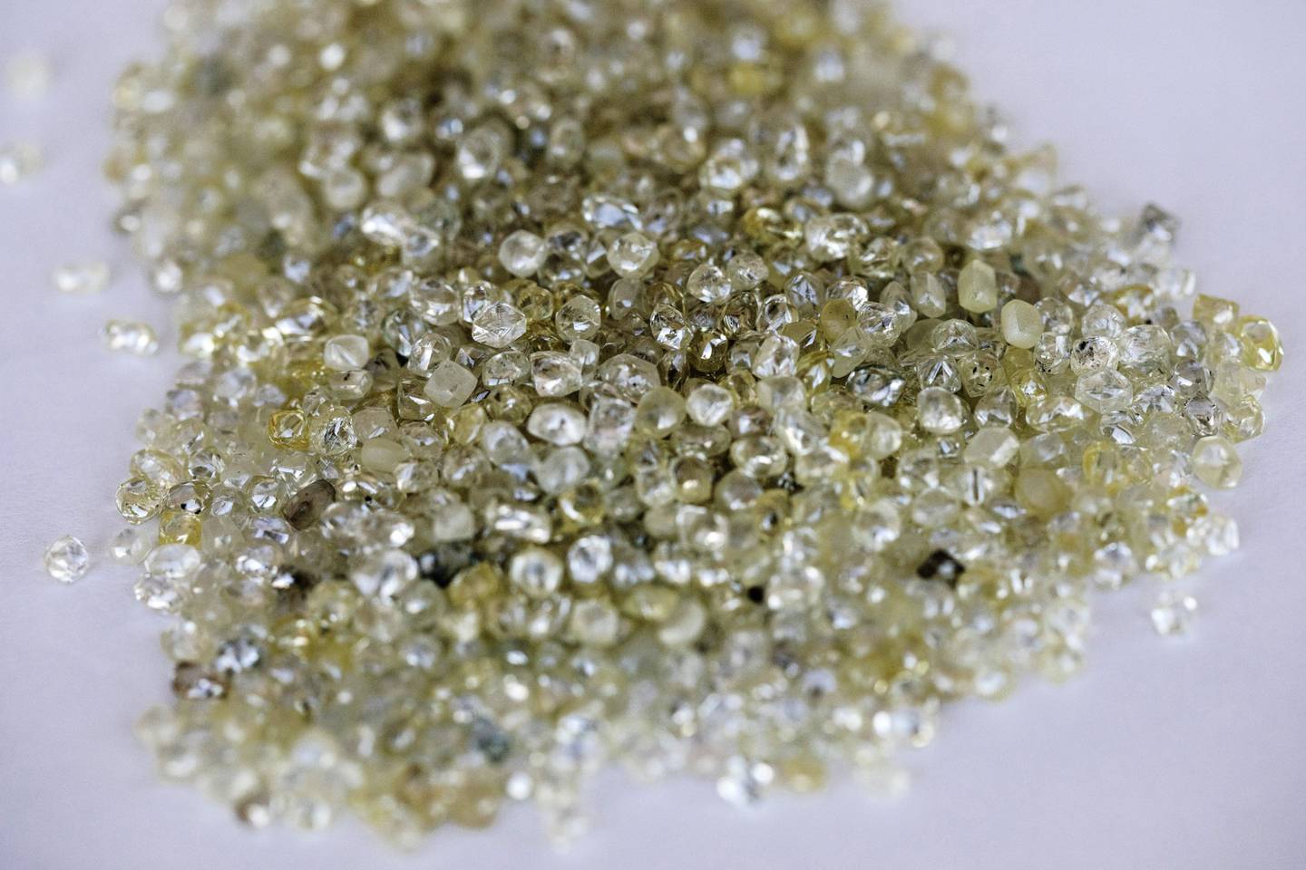 Rough diamonds sit on a sorting table at the Namibian Diamond Trading Co. (NTDC) diamond processing and valuation center, a joint venture between De Beers Group and Namdeb Diamond Corp. operated by Anglo American Plc, in Windhoek, Namibia, on Wednesday, June 14, 2017. The world's biggest diamond producer has spent $157 million on a state-of-the-art exploration vessel that will scour 6,000 square kilometers (2,300 square miles) of ocean floor for gems, an area about 65 percent bigger than Long Island. Photographer: Simon Dawson/Bloombergdfd