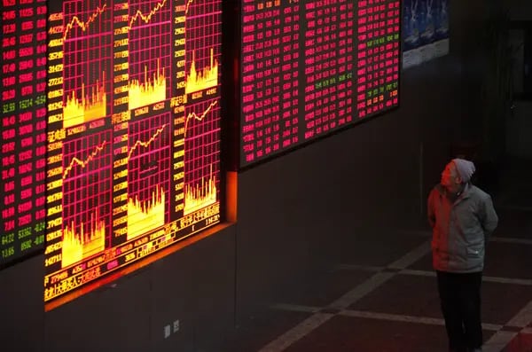 | Un inversor controla los precios de las acciones en una bolsa de valores de Shanghai, China