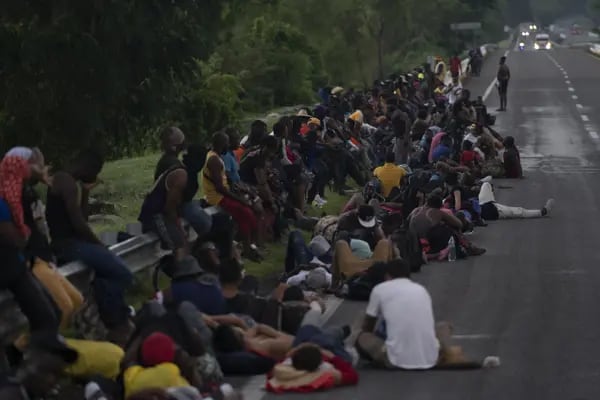 Migrantes descansan al lado de una carretera cerca de Huixtla, en Chiapas, México.