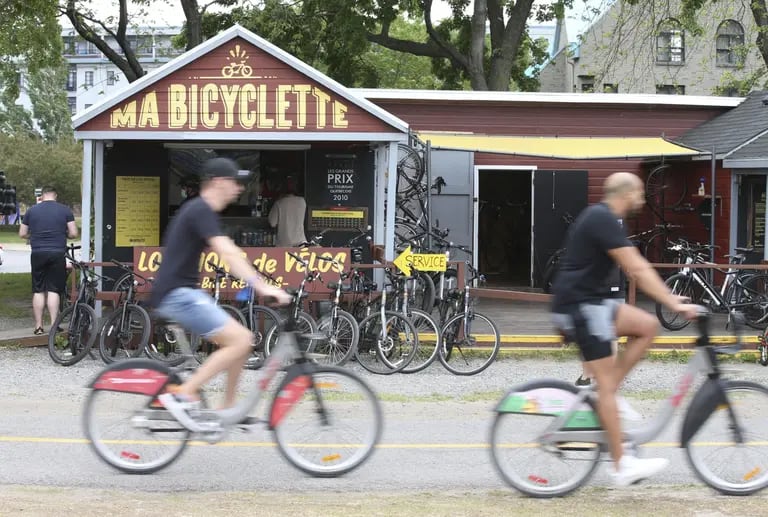 Cyclists ride past a bike rental store in downtown Montreal, Quebec.dfd