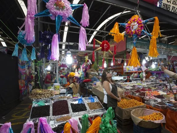Comerciantes cuelgan una piñata en su puesto del Mercado de Jamaica en Ciudad de México.