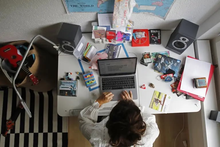 Una mujer trabaja en un ordenador portátil de Apple Inc. en un escritorio en una habitación infantil en esta fotografía arreglada tomada en Berna, Suiza, el sábado 22 de agosto de 2020.dfd