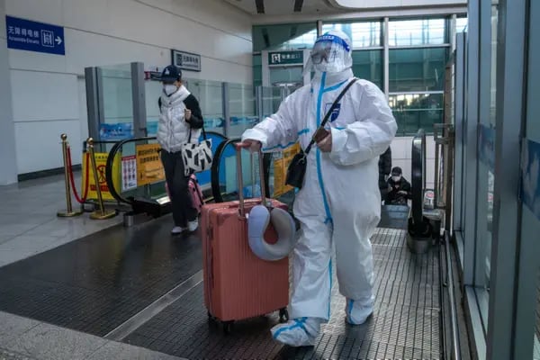 Un viajero con equipo de protección en una estación de tren de Pekín.