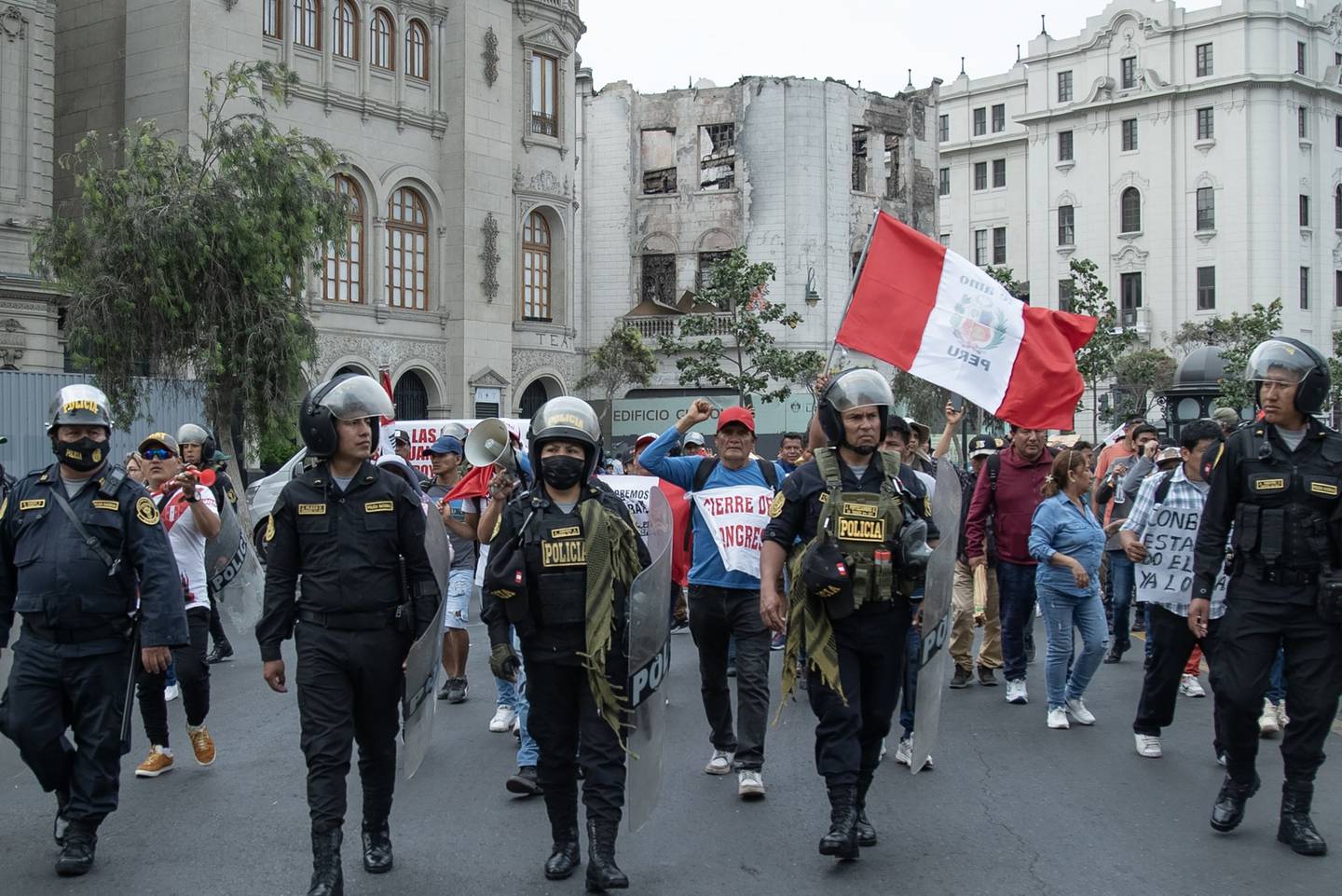 Agentes de la policía antidisturbios hacen guardia mientras los partidarios de Pedro Castillo, ex presidente de Perú, protestan por su destitución y arresto en la Plaza San Martín en Lima, Perú, el viernes 9 de diciembre de 2022.