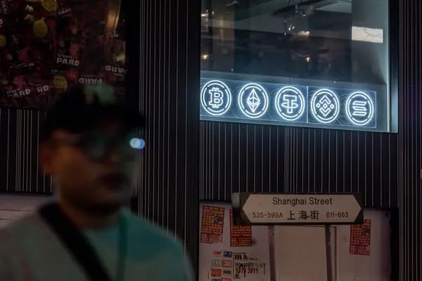 People walk past a signage of Bitcoin in Hong Kong, China, on Tuesday, Dec. 5, 2023.  Photographer: Paul Yeung/Bloomberg