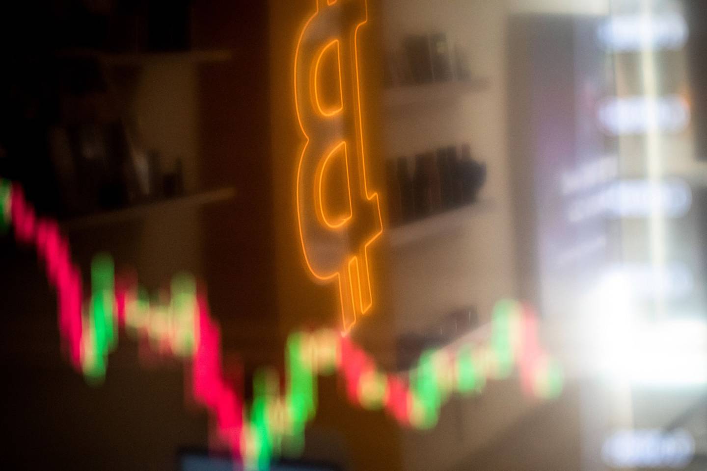 A reflection of a candlestick price chart and an illuminated Bitcoin logo inside a BitBase cryptocurrency exchange in Barcelona, Spain, on Monday, May 16, 2022. The wipeout of algorithmic stablecoin TerraUSD and its sister token Luna knocked more than $270 billion off the crypto sectors total trillion-dollar value in the most volatile week for Bitcoin trading in at least two years. Photographer: Angel Garcia/Bloombergdfd