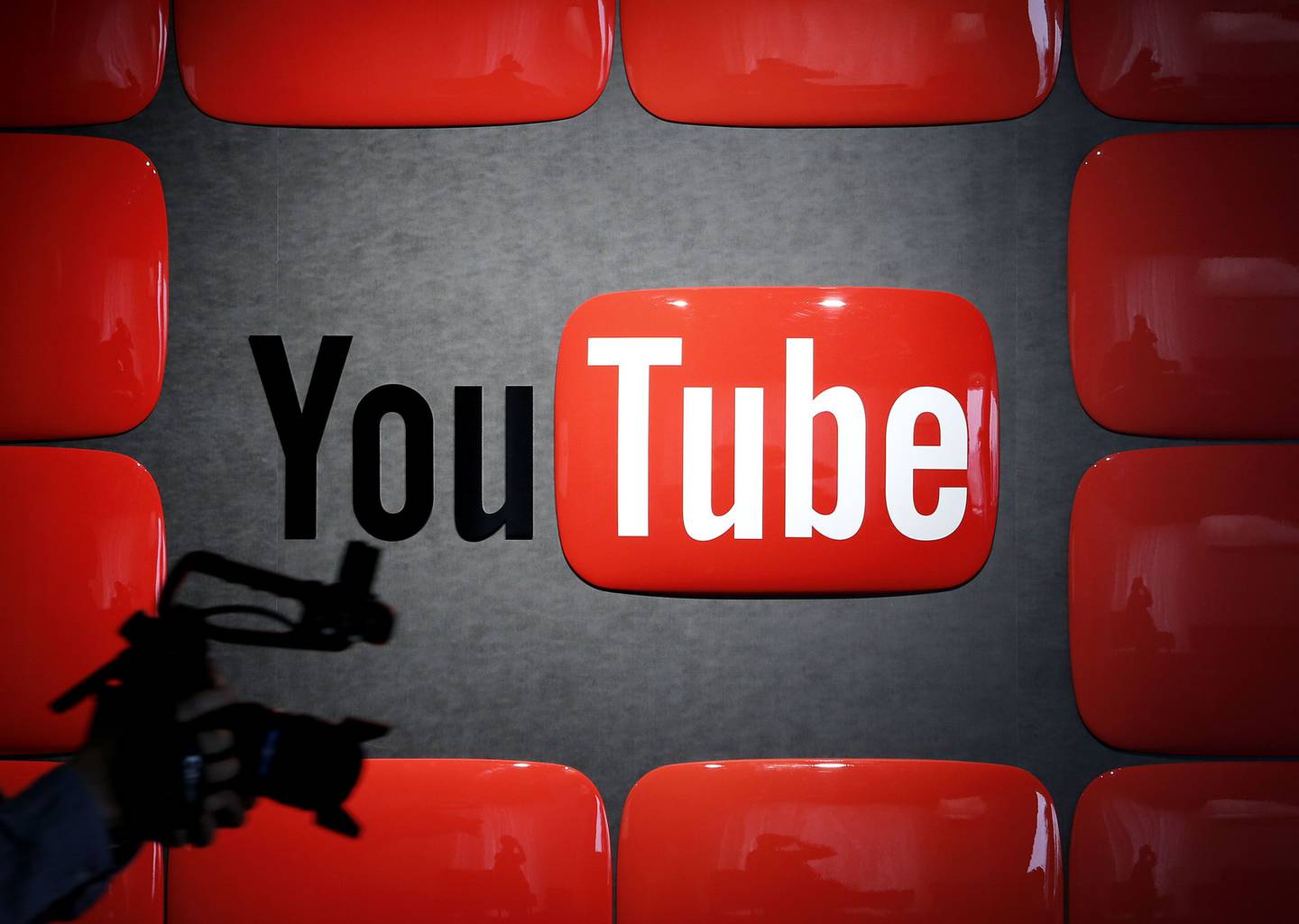 Un empleado con un equipo de grabación pasa junto a un logotipo de YouTube en el estudio YouTube Space de la empresa en Tokio.