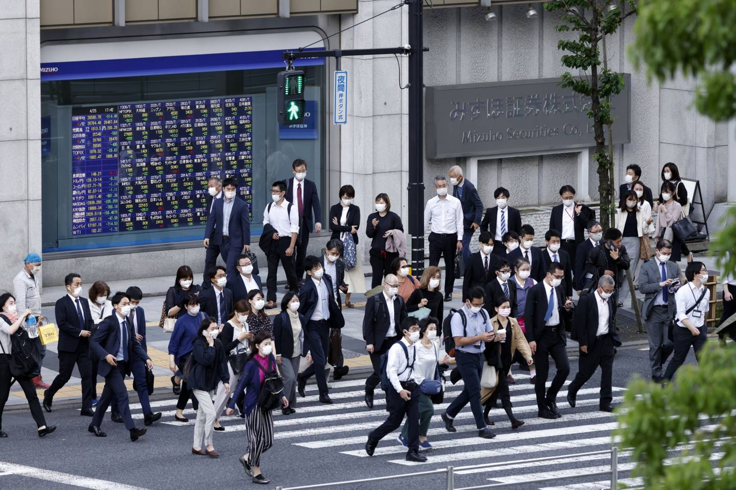 Peatones frente a Mizuho Securities Co., una unidad de Mizuho Financial Group Inc., en Tokio, Japón. Fotógrafo: Kiyoshi Ota/Bloomberg