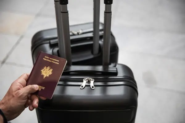 Un viajero que se dirige a Italia sostiene su pasaporte francés mientras se levantan las restricciones de viaje, en el aeropuerto Charles de Gaulle, operado por Aeroports de Paris, en Roissy, Francia, el lunes 15 de junio de 2020.