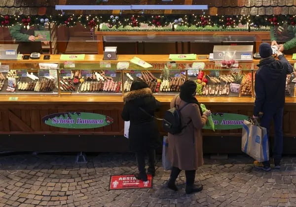 Carteles de distanciamiento social en el suelo advierten a los visitantes de que mantengan una distancia de seguridad en un mercado navideño de Fráncfort.