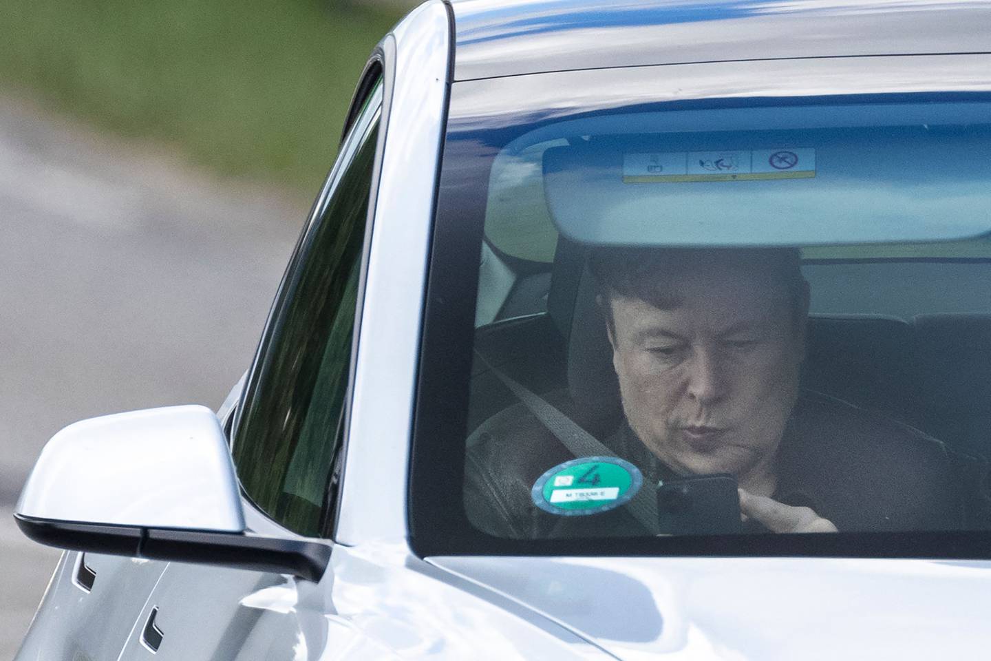 Elon Musk con su teléfono en un Tesla