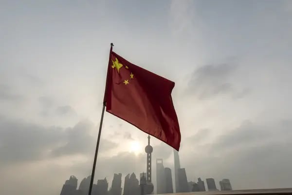 Una bandera china frente a edificios en el distrito financiero de Lujiazui de Pudong en Shanghái, China, el lunes 17 de octubre de 2022.