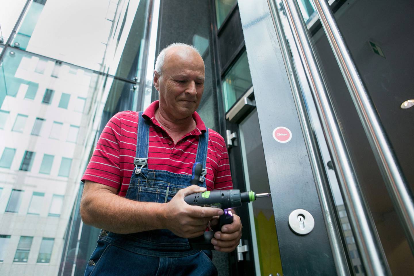 Jochen Heyn, un jubilado de 63 años, repara una cerradura en un edificio de oficinas donde trabaja cinco horas y media a la semana como técnico de mantenimiento, en Berlín, Alemania, el miércoles 22 de abril de 2015.