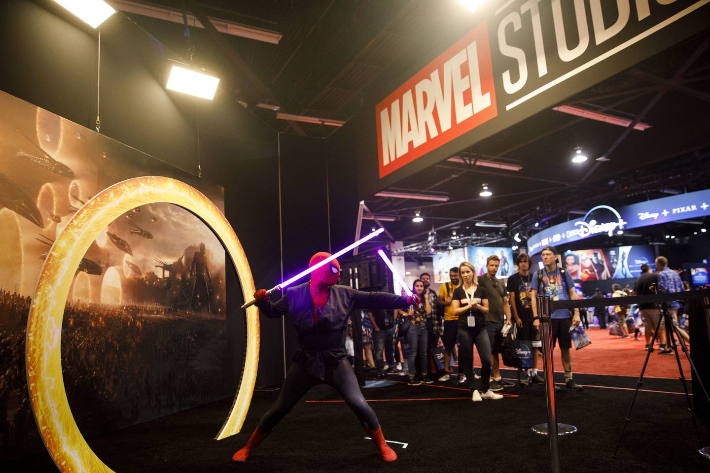 An attendee dressed as Spider-Man holds lightsabers at a Marvel Studios photo booth during the D23 Expo 2019 in Anaheim, California, U.S., on Friday, Aug. 23, 2019. Walt Disney Co. is turning the D23 Expo, the biennial fan conclave, into a big push for its new streaming services. Photographer: Patrick T. Fallon/Bloomberg