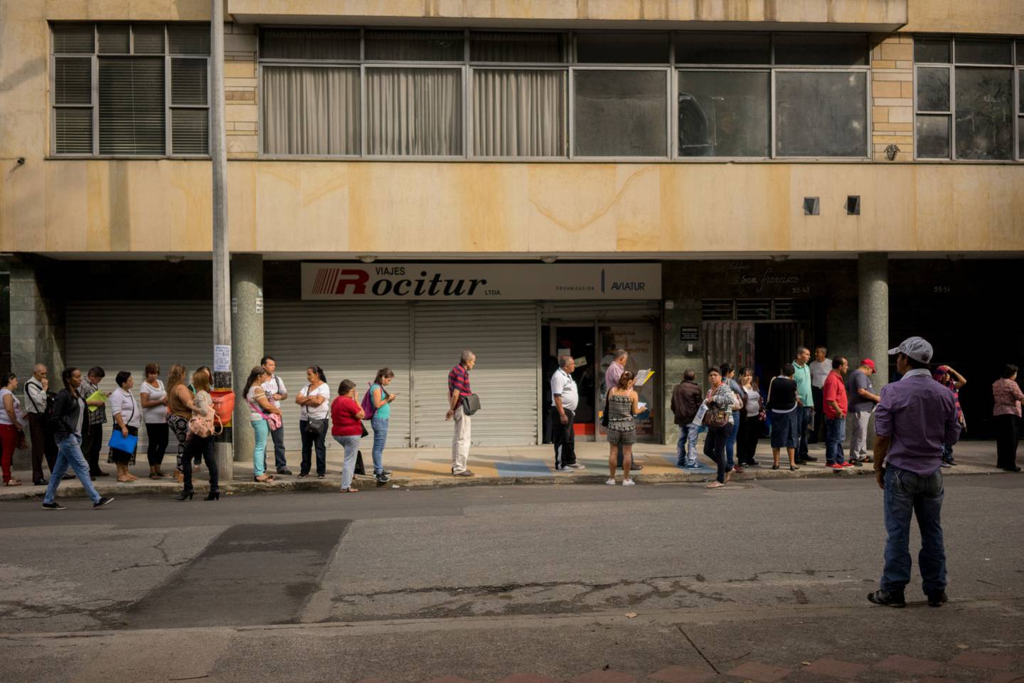 La gente espera en la fila afuera de un centro de empleo.