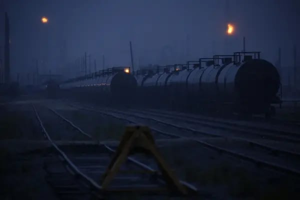 Tren de carga con carrotanques que transportan combustibles fósiles al anochecer en Texas, EE. UU.