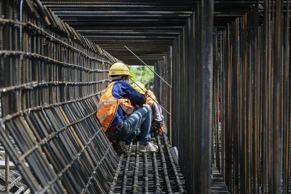 Obreros trabajan en la construcción de una autopista elevada en las afueras de Shanghái.