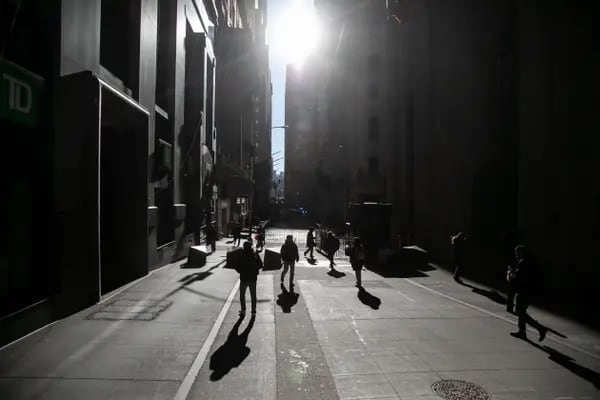 Pedestrians walk along Wall Street near the New York Stock Exchange.