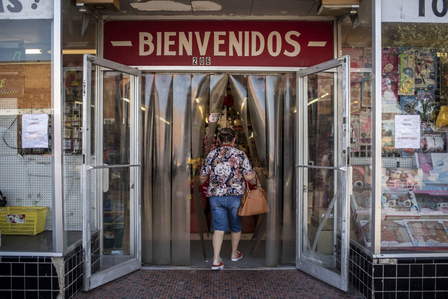 A customer enters a store with a "Welcome" sign in Spanish near the US-Mexico border in Eagle Pass, Texas.
