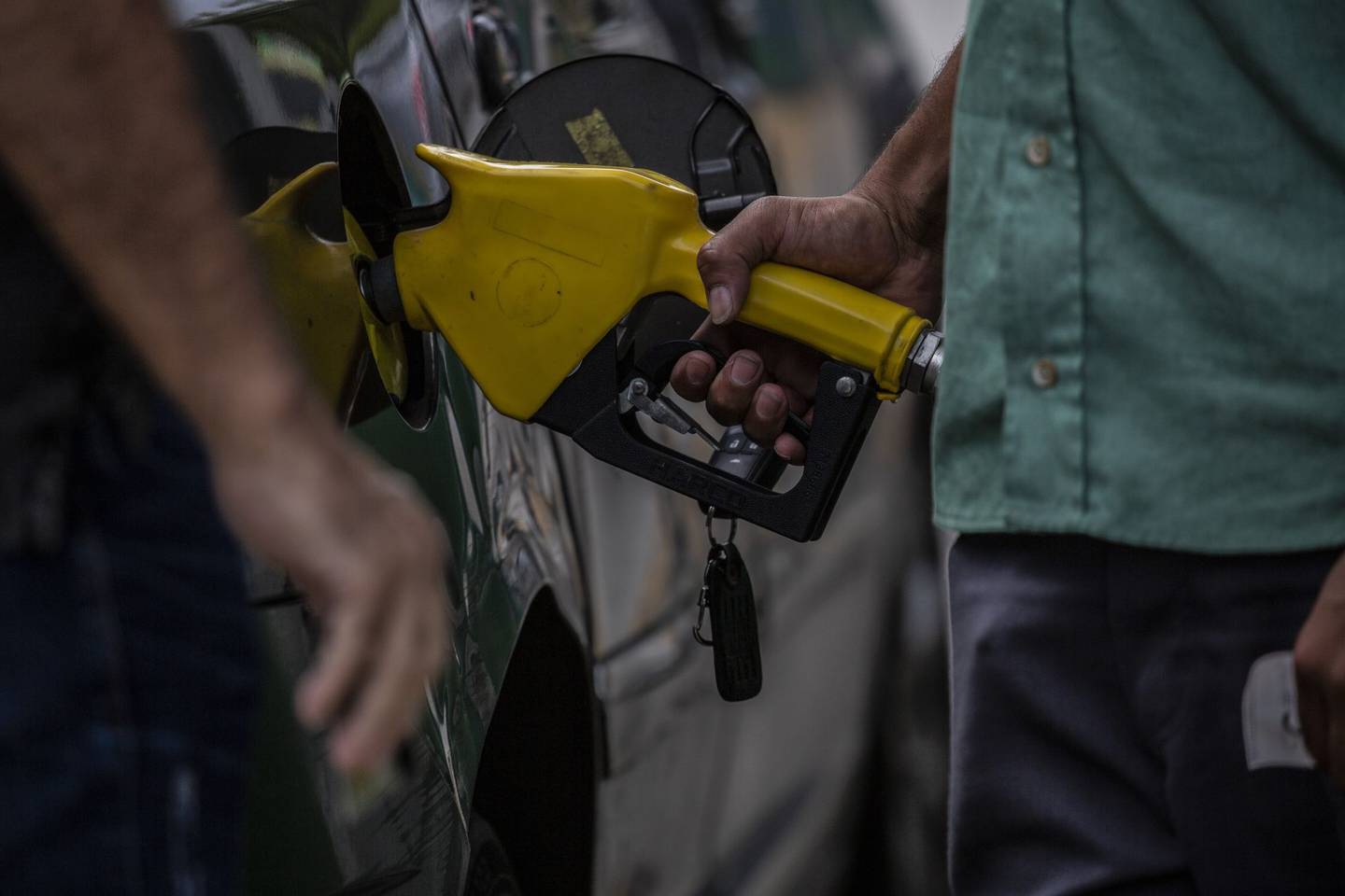 A worker refuel a vehicles at a Petrobras gas station in Rio de Janeiro, Brazil.