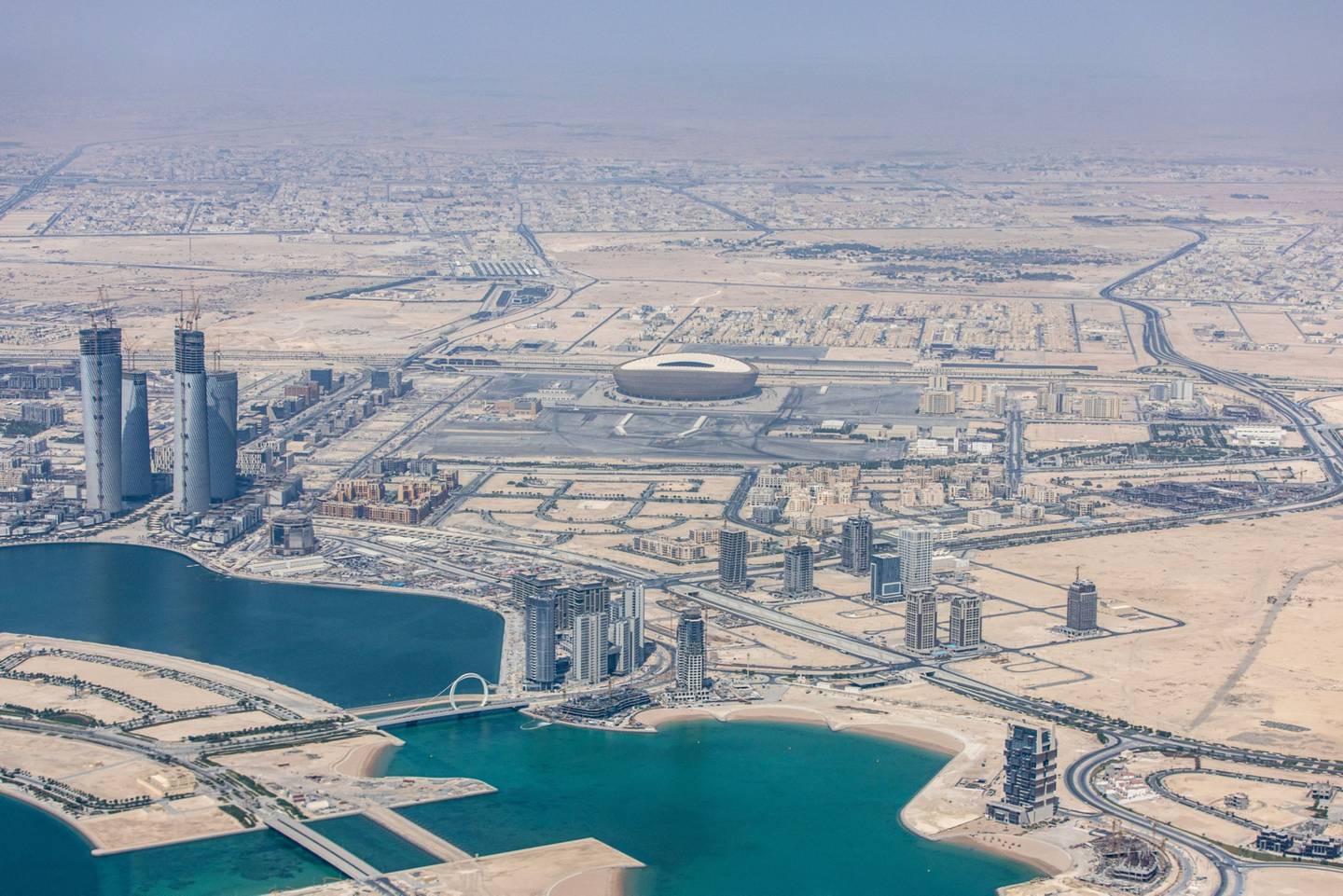 El estadio de fútbol de Lusail, sede de la Copa Mundial de la FIFA 2022, más allá de los rascacielos residenciales y comerciales de Doha, Qatar, el lunes 20 de junio de 2022. Fotógrafo: Christopher Pike/Bloombergdfd
