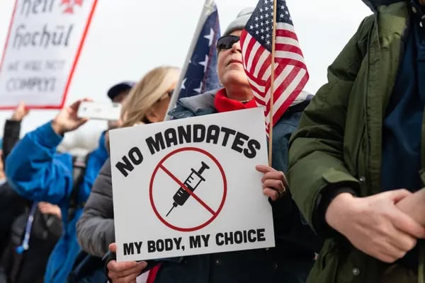 Una manifestante sostiene un cartel durante una concentración contra el mandato de las vacunas en el Lincoln Memorial, en el National Mall de Washington.