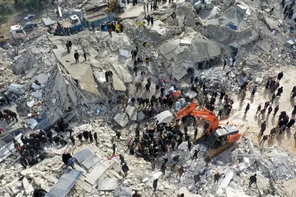 Esta vista aérea muestra a los residentes, ayudados por equipos pesados, buscando víctimas y supervivientes entre los escombros de los edificios derrumbados tras un terremoto en el pueblo de Besnia, cerca del twon de Harim, en la provincia siria de Idlib, controlada por los rebeldes, en la frontera con Turquía, el 6 de febrero de 2022. Fotógrafo: Omar Haj Kadour/AFP/Getty Images