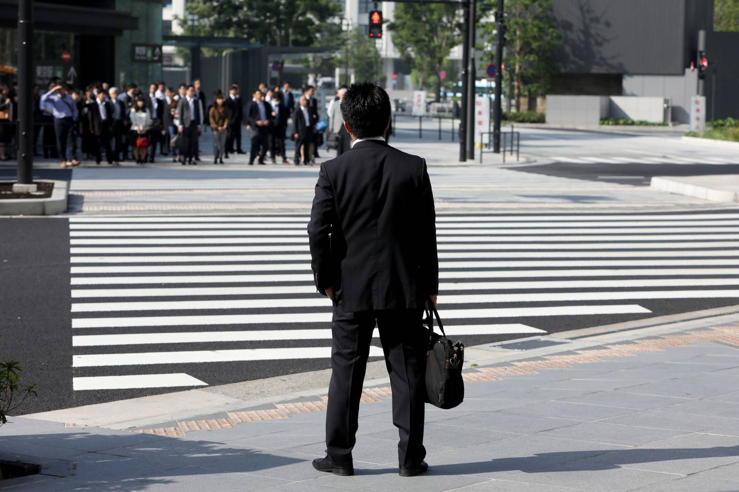 Un hombre espera para cruzar la calle en Tokyo.
