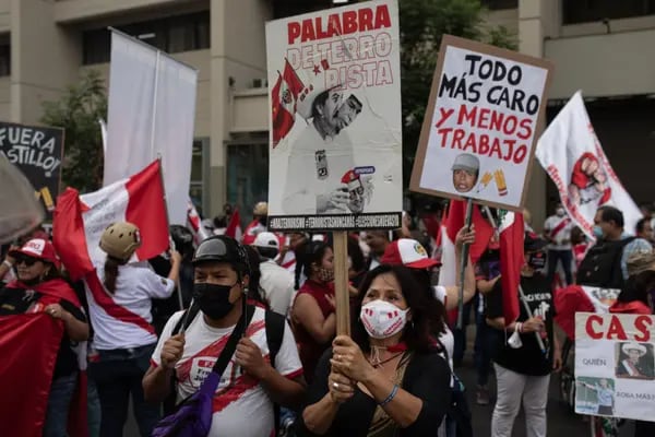 Manifestantes contra el presidente de Perú, Pedro Castillo, sostienen pancartas frente al Palacio Legislativo en Lima.