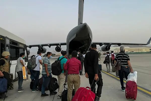 Nacionales indios abordan un avión en el aeropuerto de Kabul.