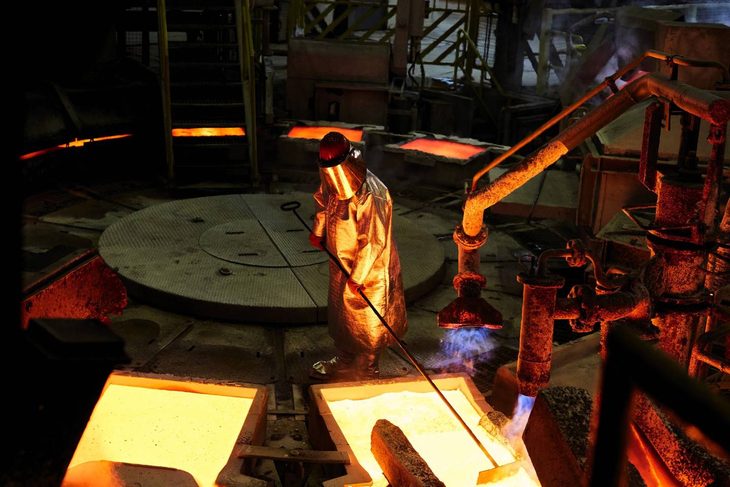 Un trabajador con ropa protectora resistente al calor supervisa la línea de producción de moldes de cobre líquido en la planta de fundición de KGHM Polska Miedz SA en Glogow, Polonia, el martes 9 de marzo de 2021. Fotógrafo: Bartek Sadowski/Bloomberg