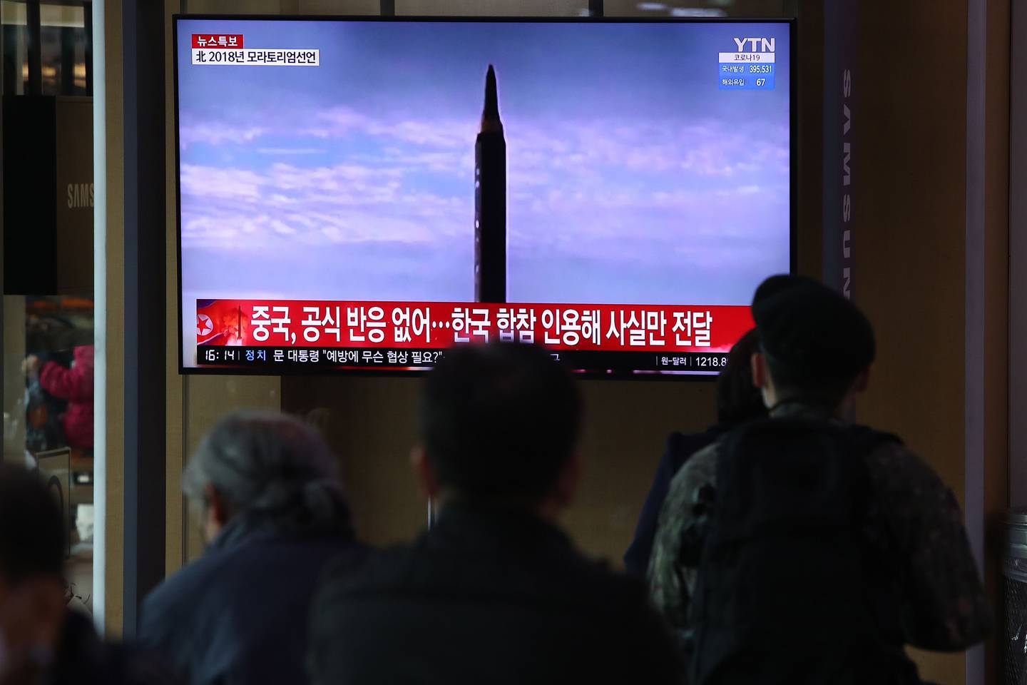 Unas personas observan un televisor en la estación de tren de Seúl que muestra una imagen de archivo del lanzamiento de un misil norcoreano el 24 de marzo de 2022 en Seúl, Corea del Sur.