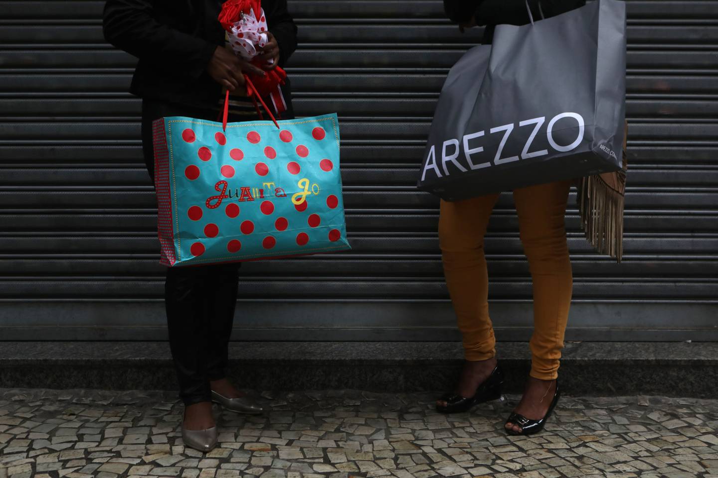 Shoppers hold Juanita Jo and Arezzo bags in downtown Rio de Janeiro