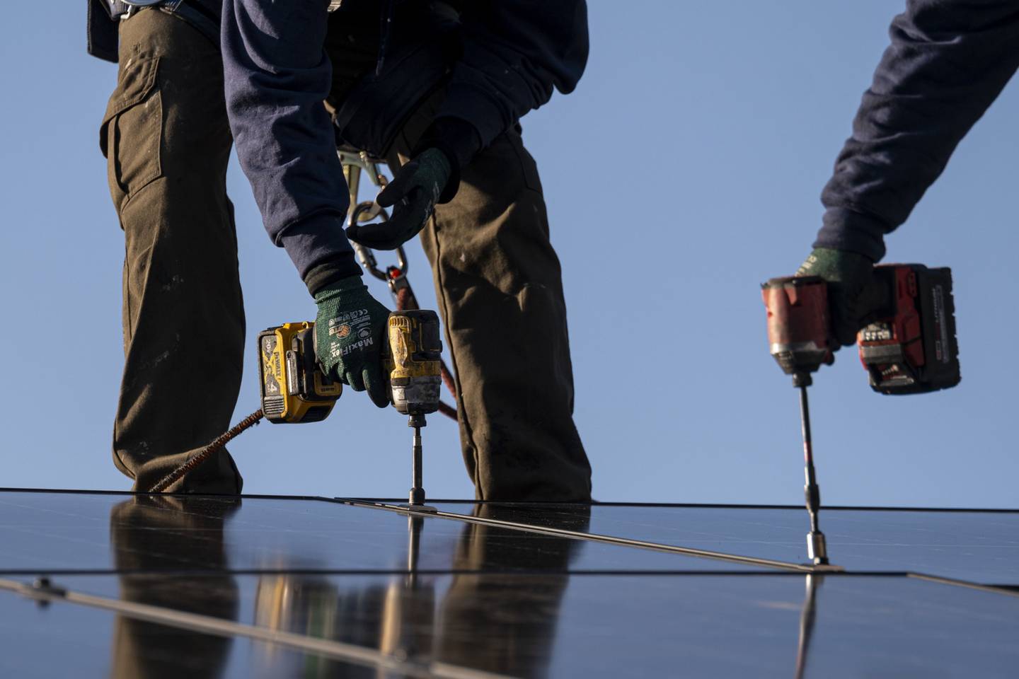 Trabajadores instalan paneles solares en un techo en San Jose, California