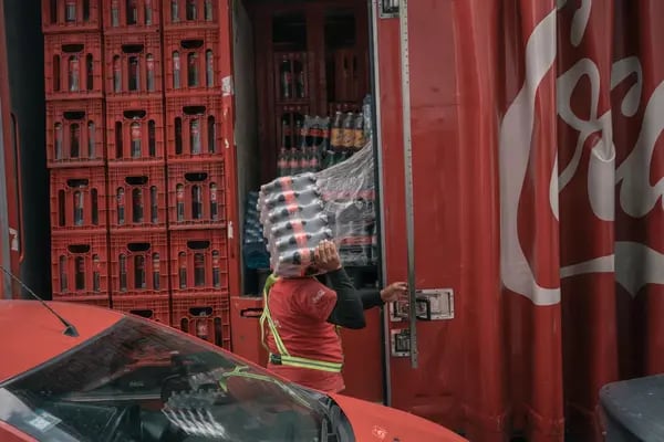 Un trabajador descarga botellas de Coca-Cola de un camión en un mercado de Toluca, estado de México, el martes 9 de agosto de 2022.