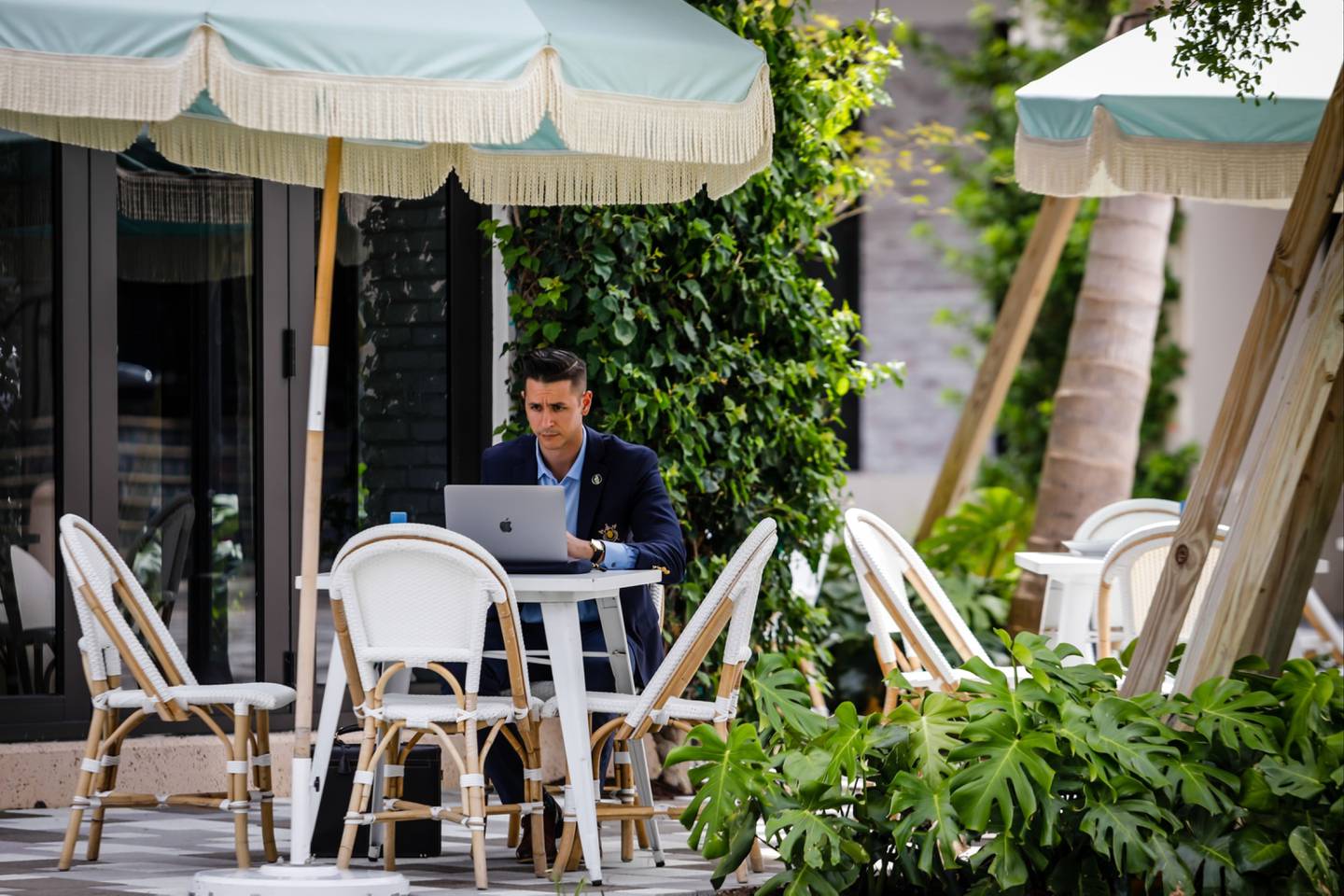 Un cliente trabaja en una computadora portátil en el comedor al aire libre del restaurante Pura Vida en Rosemary Avenue en West Palm Beach, Florida, EE.UU., el viernes 27 de agosto de 2021.