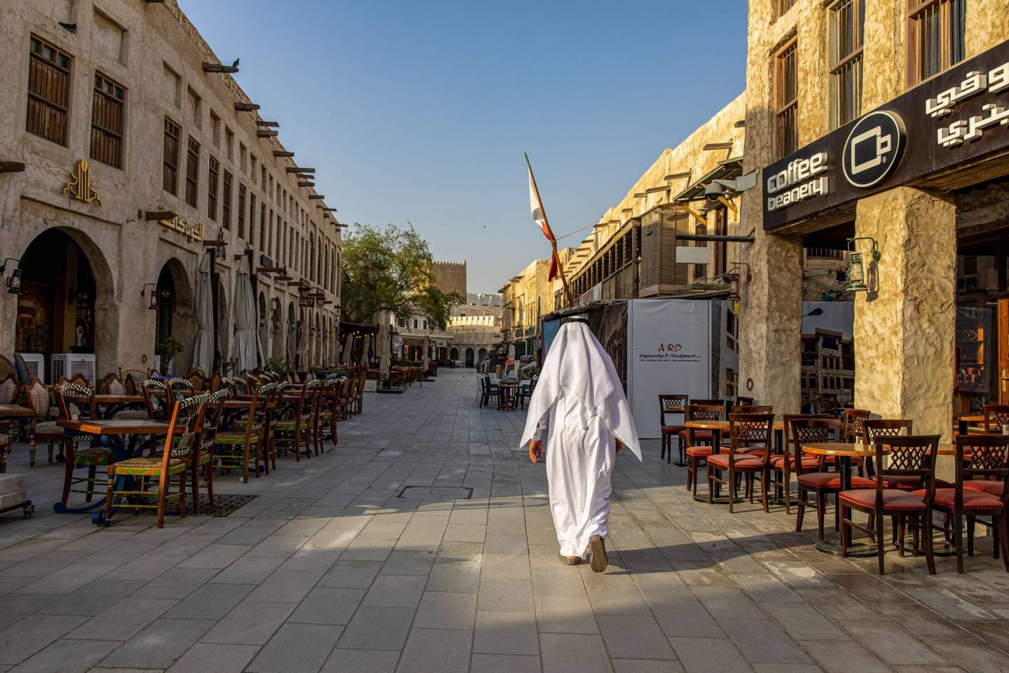 Un peatón camina junto a las terrazas vacías de los cafés en la zona de Souq Waqif de Doha, Qatar, el jueves 23 de junio de 2022.