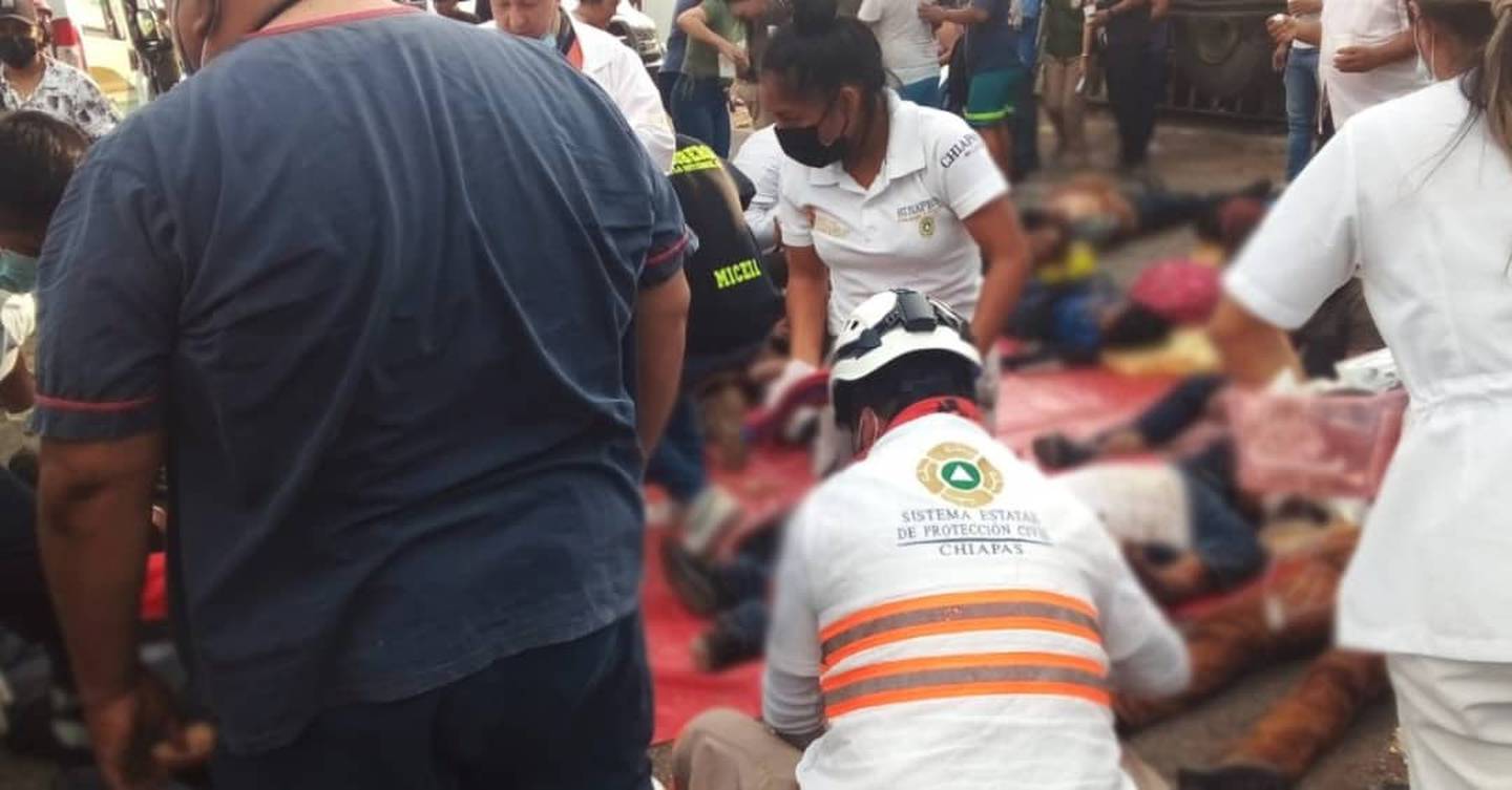 Empleados de Protección Civil de Chiapas atienden a migrantes heridos tras un choque del camión que los transportaba.