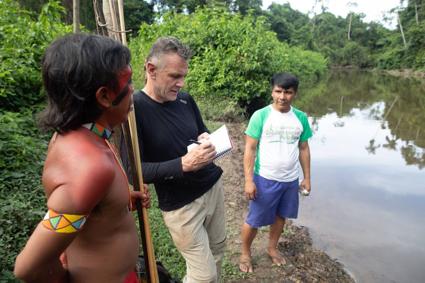 Foreign correspondent Dom Phillips (C) talks to two indigenous men in Aldeia Maloca Papiú, Roraima State.