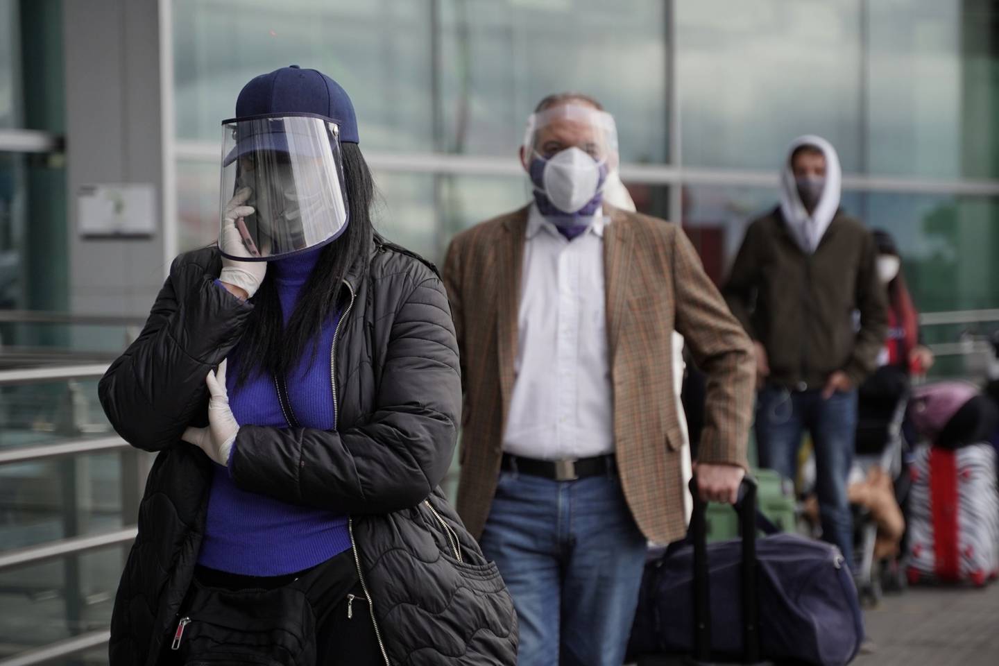 Pasajeros con equipo de protección personal hacen fila en el Aeropuerto Internacional El Dorado (BOG) en Bogotá, Colombia, el jueves 21 de mayo de 2020.