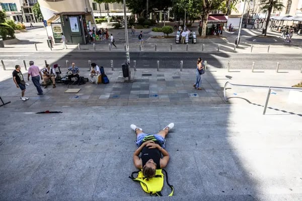 A pedestrian lays in the shade during high temperatures at La Setas in central Seville, Spain, on Thursday, July 6, 2023.