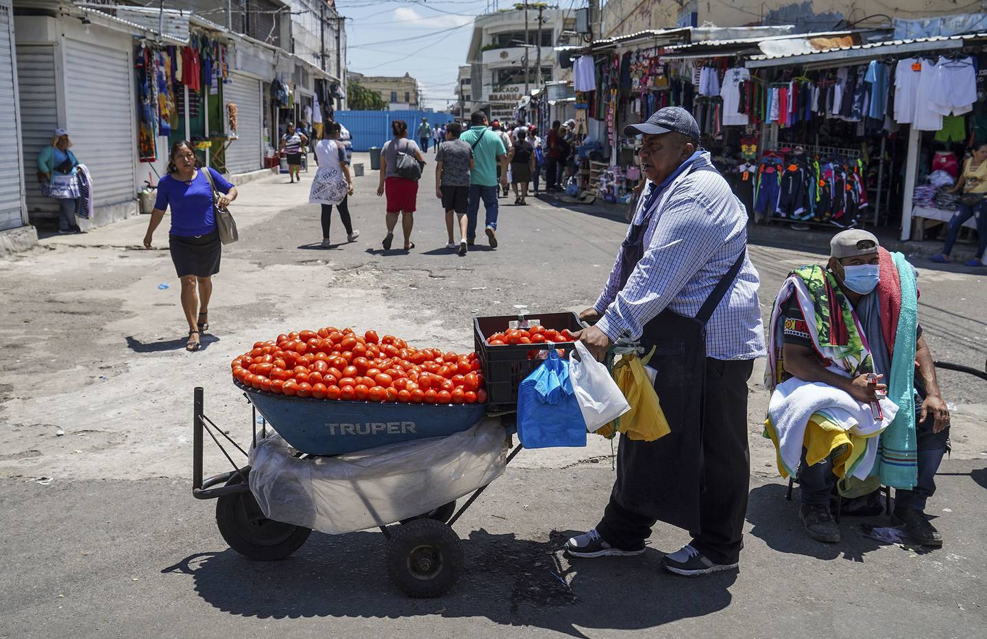 Street vendors at a local market in San Salvador, El Salvador. The nation has faced repeated slashing of its credit rating. Photographer: Armando Constanza/Getty Images