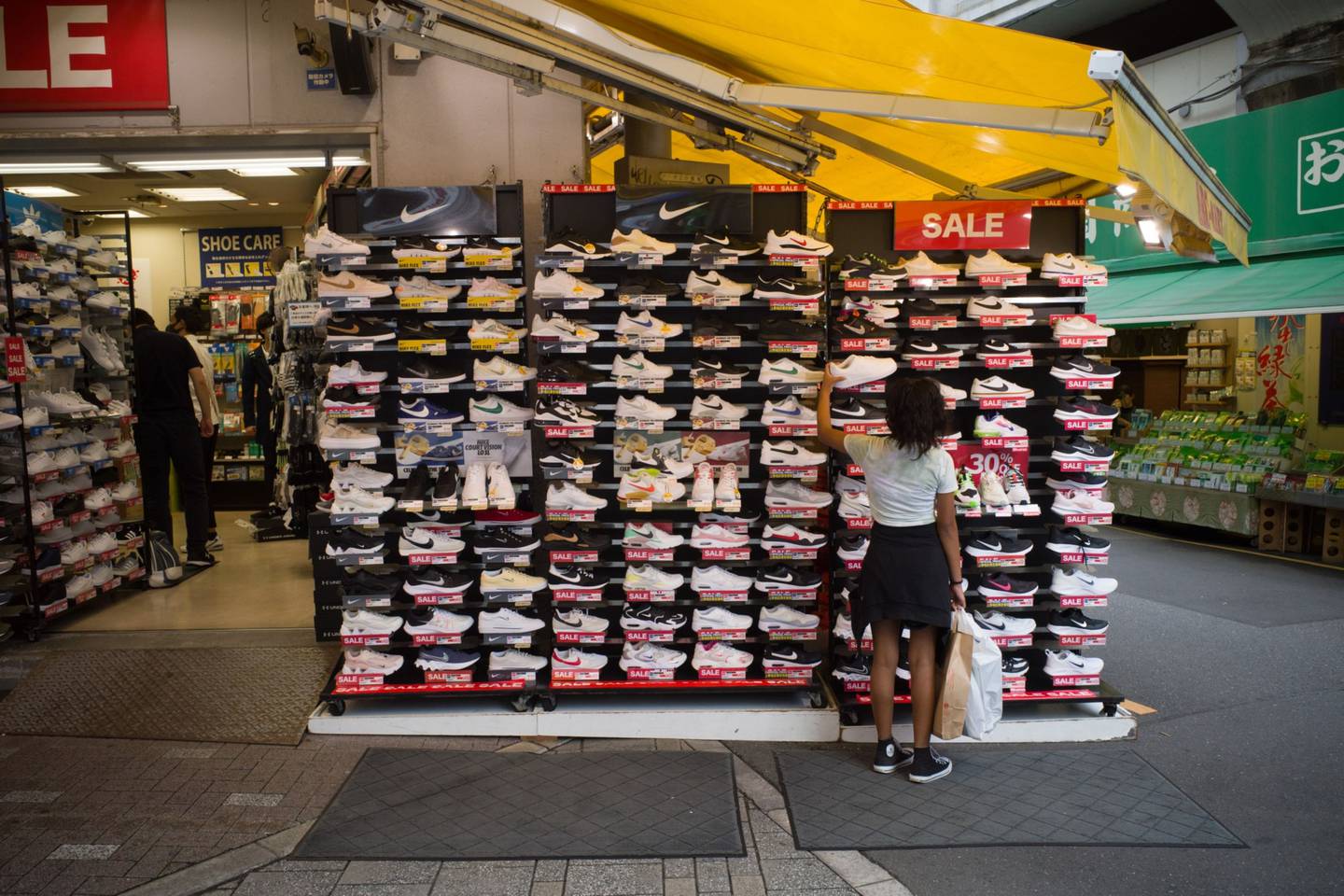 Un comprador observa unas zapatillas Nike a la venta en la calle comercial Ameyoko de Tokio, Japón, el domingo 5 de septiembre de 2021.