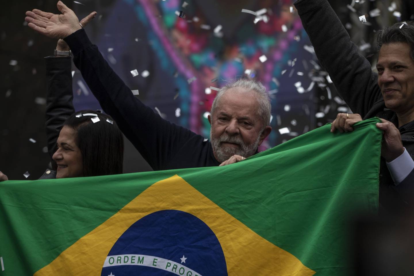 El expresidente Lula sostiene la bandera brasileña durante un acto de campaña en 2022