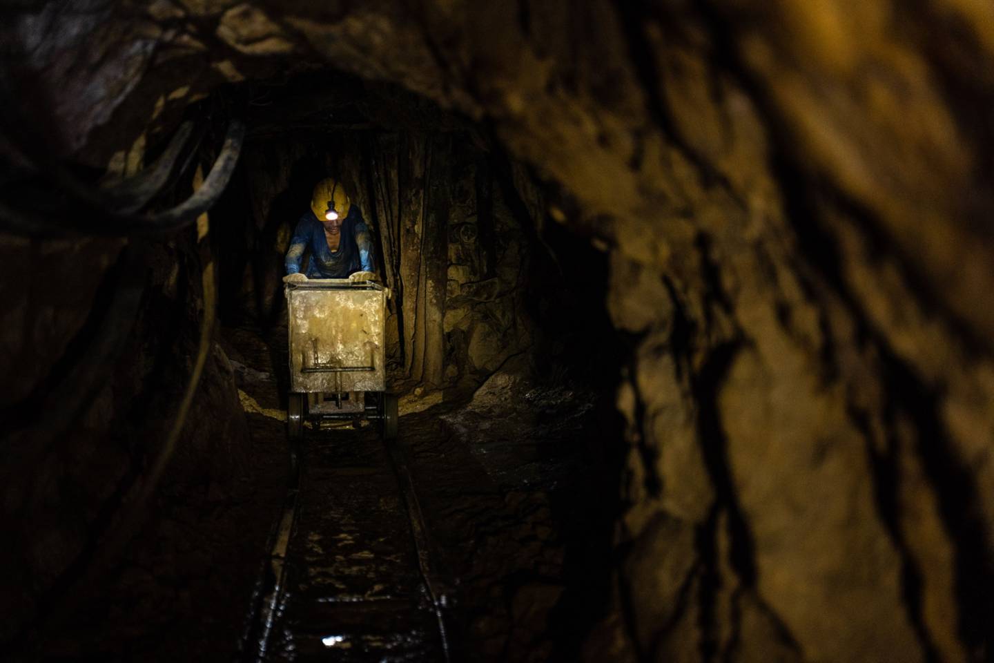 Un trabajador empuja un carrito de materias primas en una mina de oro en el departamento de Caldas, Colombia, el martes 29 de junio de 2021