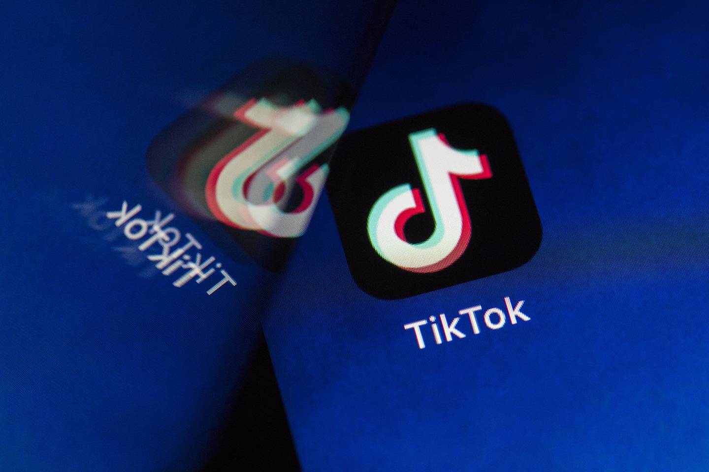 ByteDance Ltd.'s TikTok app button, reflected in a mirror, is arranged for a photograph on a smartphone