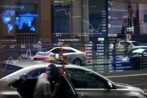 Los vehículos se reflejan en una ventana mientras los tableros electrónicos muestran información bursátil en la Bolsa de Valores de Australia, operada por ASX Ltd., en Sídney, Australia, el viernes 11 de enero de 2019. Fotógrafo: Lisa Maree Williams/Bloomberg