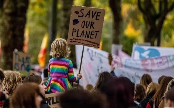Un niño tiene una pancarta que dice "Salva el planeta" durante el COP26, en noviembre del 2021.