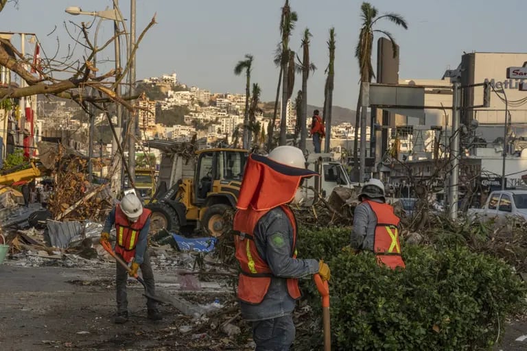 Construction workers clean up debris in the aftermath of Hurricane Otis in Acapulco, Guerrero state, Mexico, on Tuesday, Nov. 14, 2023. Mexico's lower house of Congress approved the spending portion of the 2024 budget and sent it to the president for signing, without including extra funding for the recovery of hurricane-hit Acapulco. Photographer: Alejandro Cegarra/Bloombergdfd